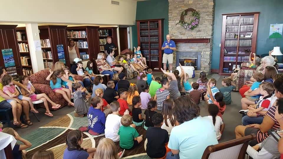 man speaking to a group of children