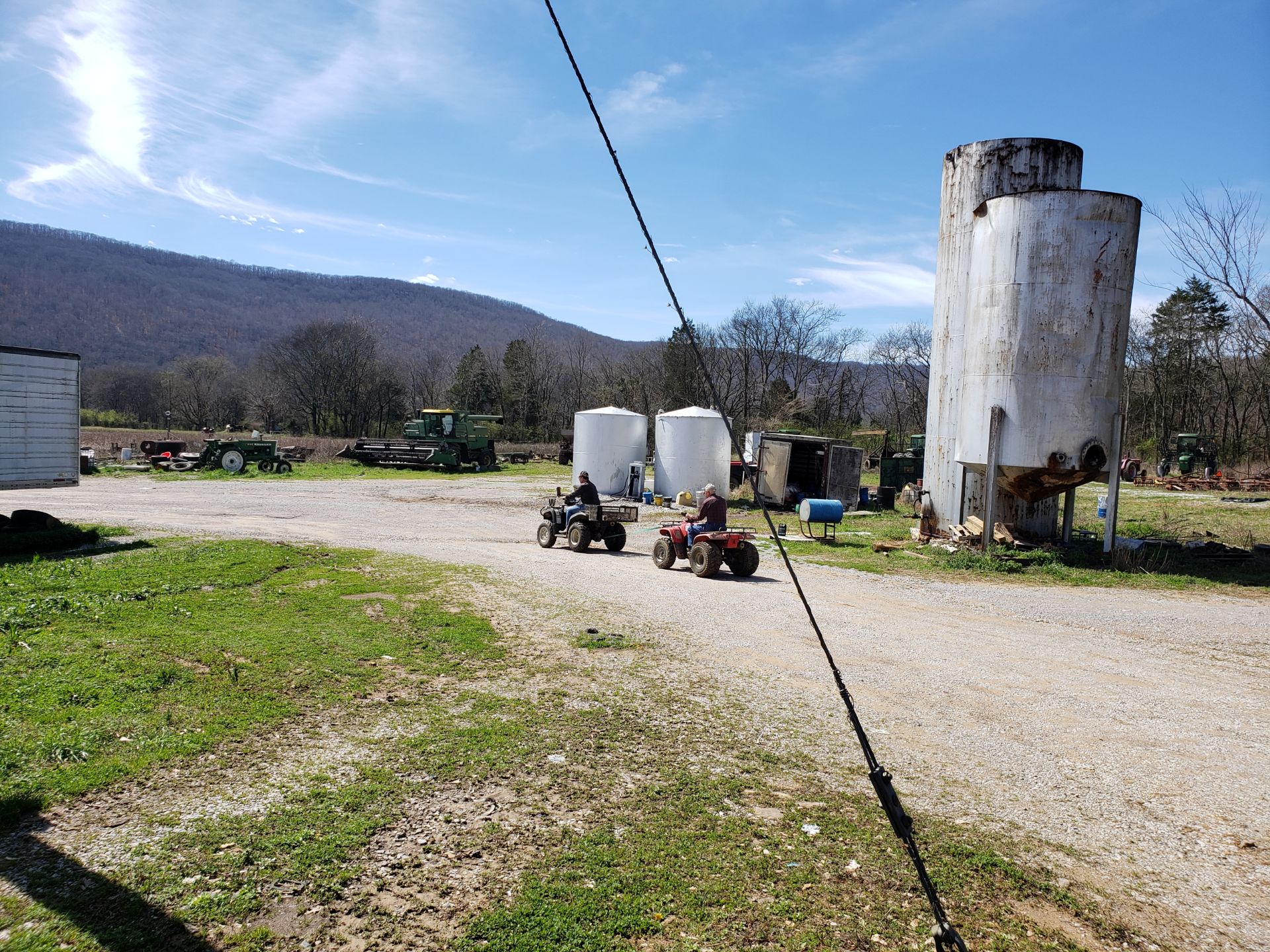 A farm with equipement in the distance.