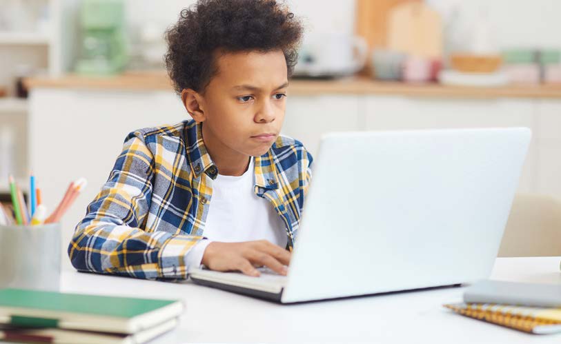 Young boy working on laptop.