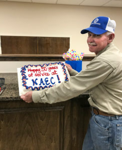 Eugene Tally holding a cake that has icing saying "Happy 50 years of service at NAEC"
